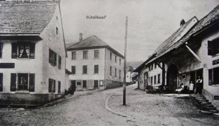 Schulgasse - Einfahrt von der Hauptstrasse her, rechts die alte Post, links die Handlung Kaufmann